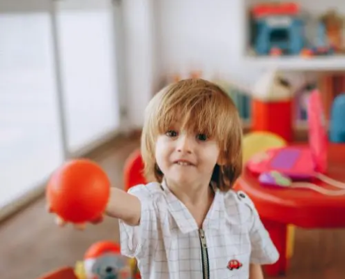 Chłopiec bawiący się piłką w przedszkolu