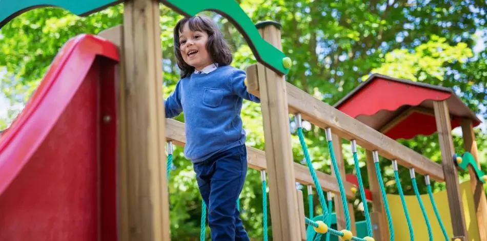 Dziecko bawiące się na placu zabaw na świeżym powietrzu obok przedszkola w Katowicach