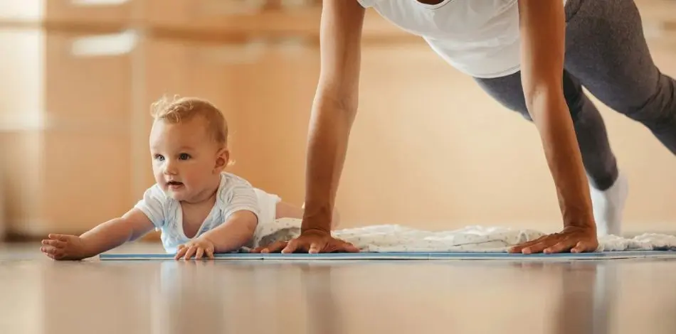 Dziecko leżące na macie obok mamy na dodatkowych zajęciach
